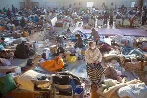 Picture of gymnasium filled with cots and very cluttered